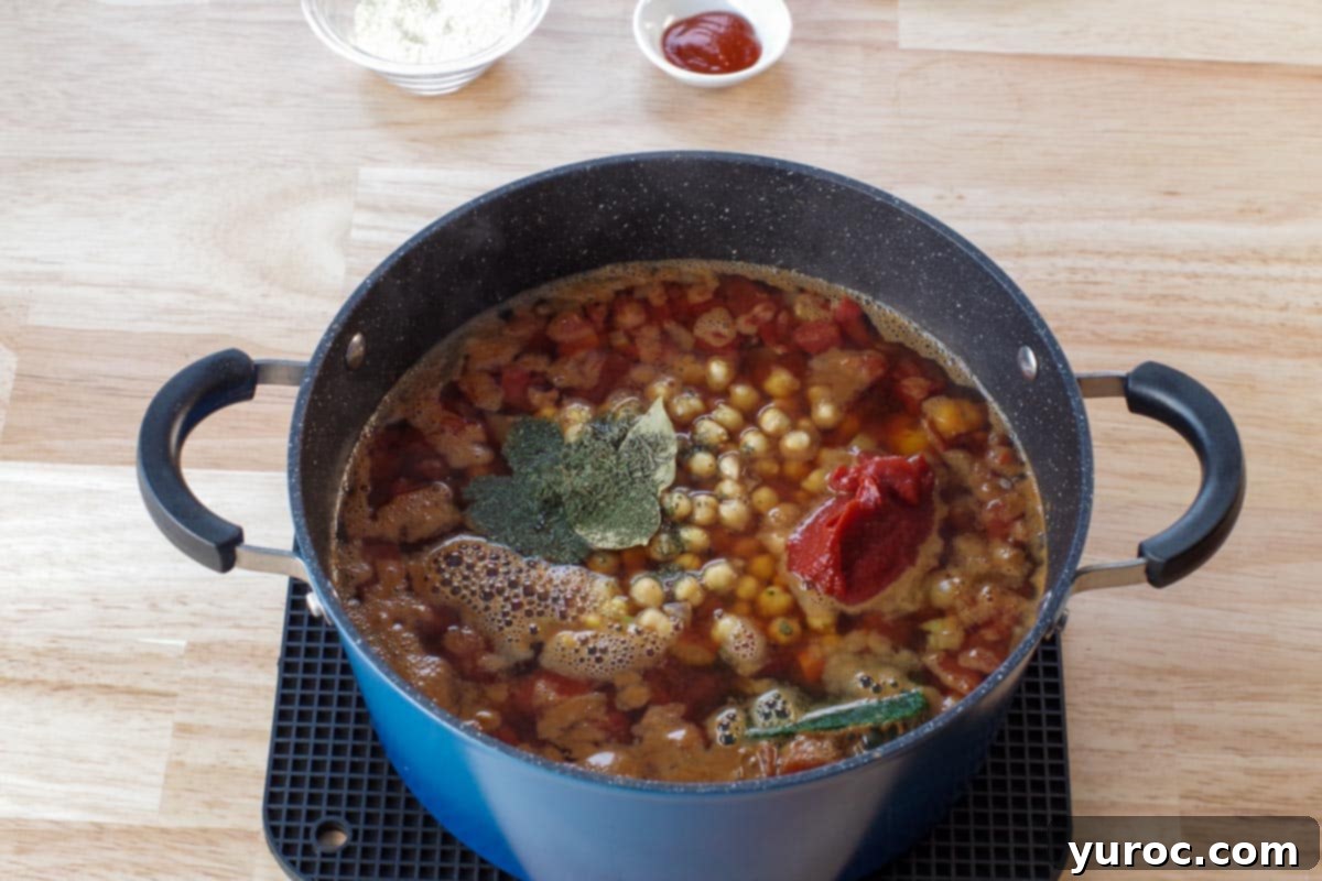 Wholesome Minestrone Made Easy 4 Minestrone soup in a pot after all the main ingredients have been added, including pasta, beans, and frozen vegetables, simmering to perfection before final garnishes.
