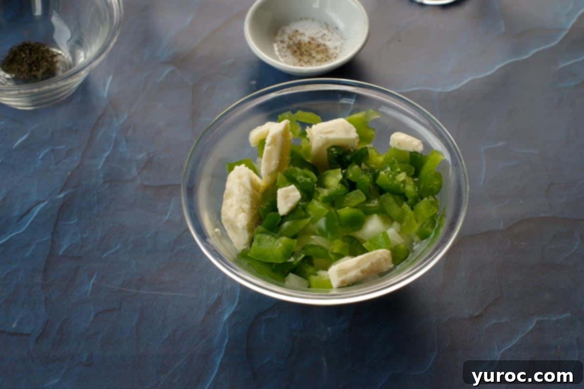 Diced onion, butter, and green pepper in a small glass bowl