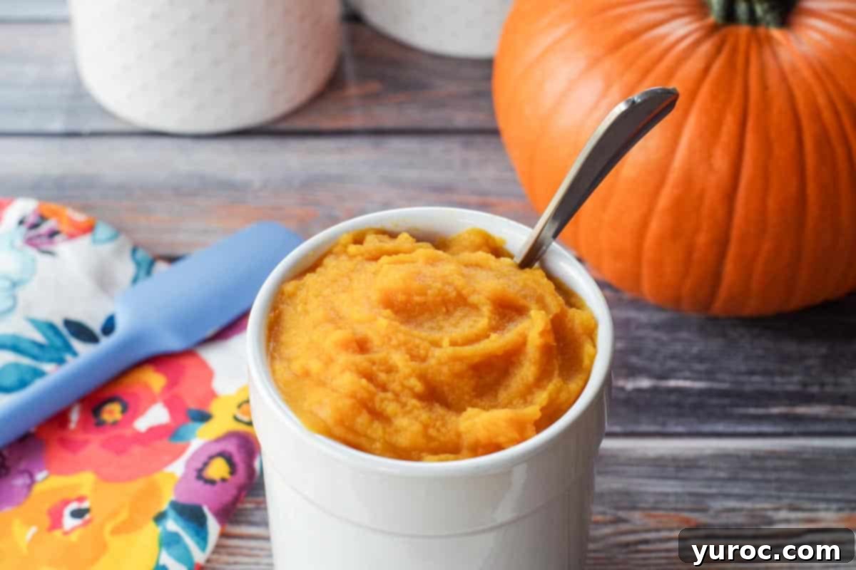 white canister with pumpkin puree in it, as well as spoon and whole pumpkin in background