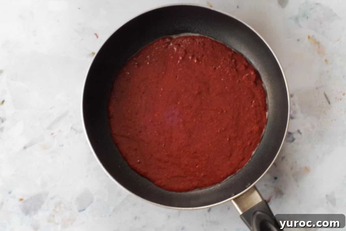 Healthy Red Velvet Pancakes with Luscious Chocolate Cream Cheese Butter 11 Healthy Red Velvet pancake batter being poured into an 8-inch frying pan.