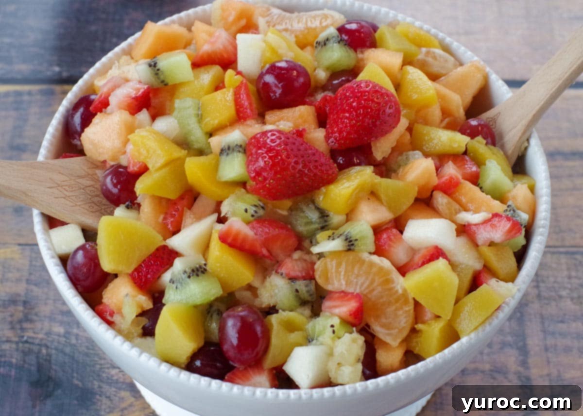 Healthy Red Velvet Pancakes with Luscious Chocolate Cream Cheese Butter 20 Classic fruit salad in a white bowl with wooden serving spoons on a faux wooden surface.