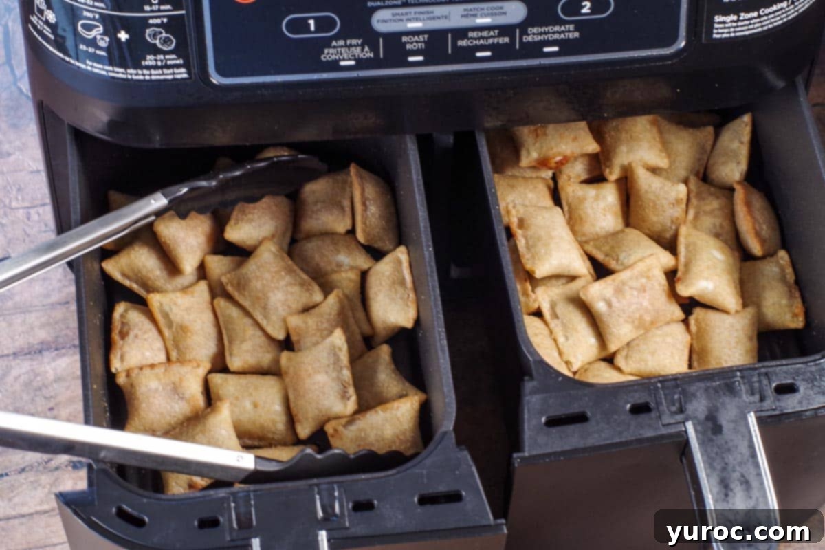 Freshly cooked, golden-brown air fryer pizza bites resting in an air fryer basket, steam gently rising.