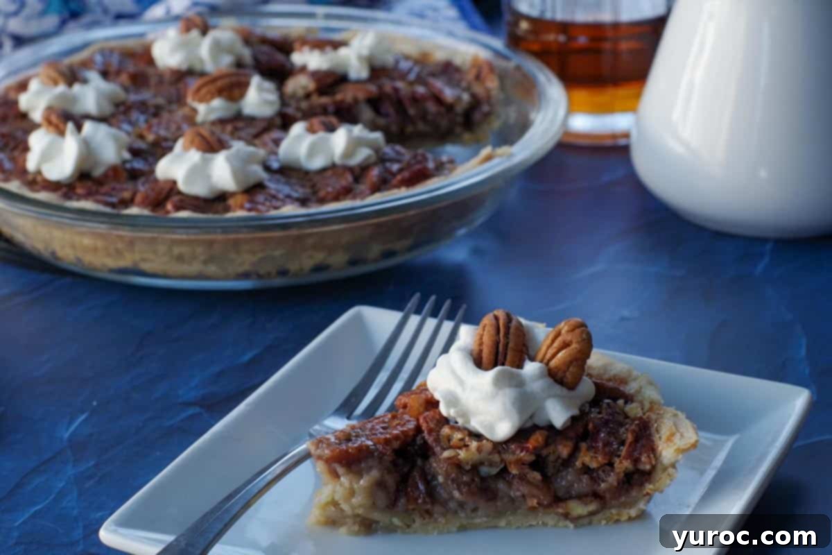 a piece of maple pecan pie on a white plate with a fork and remainder of whole pie in the background