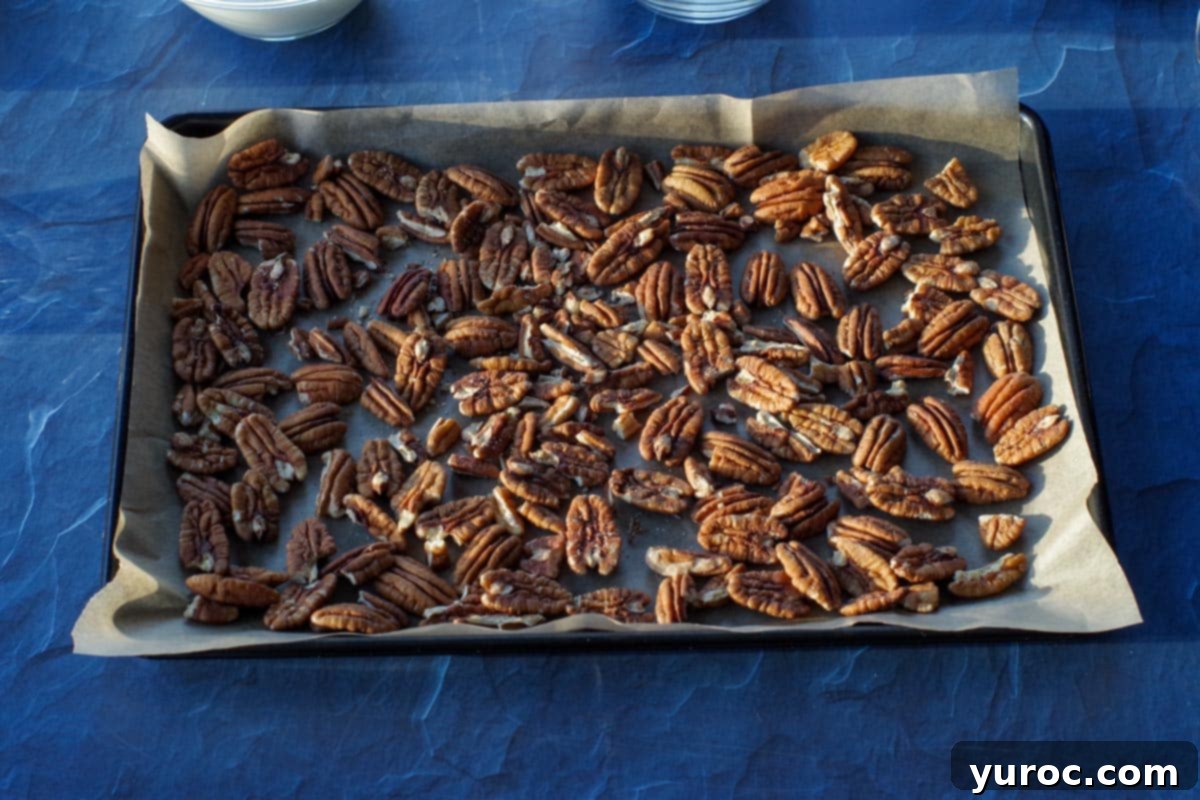 pecan halves on a parchment lined baking sheet