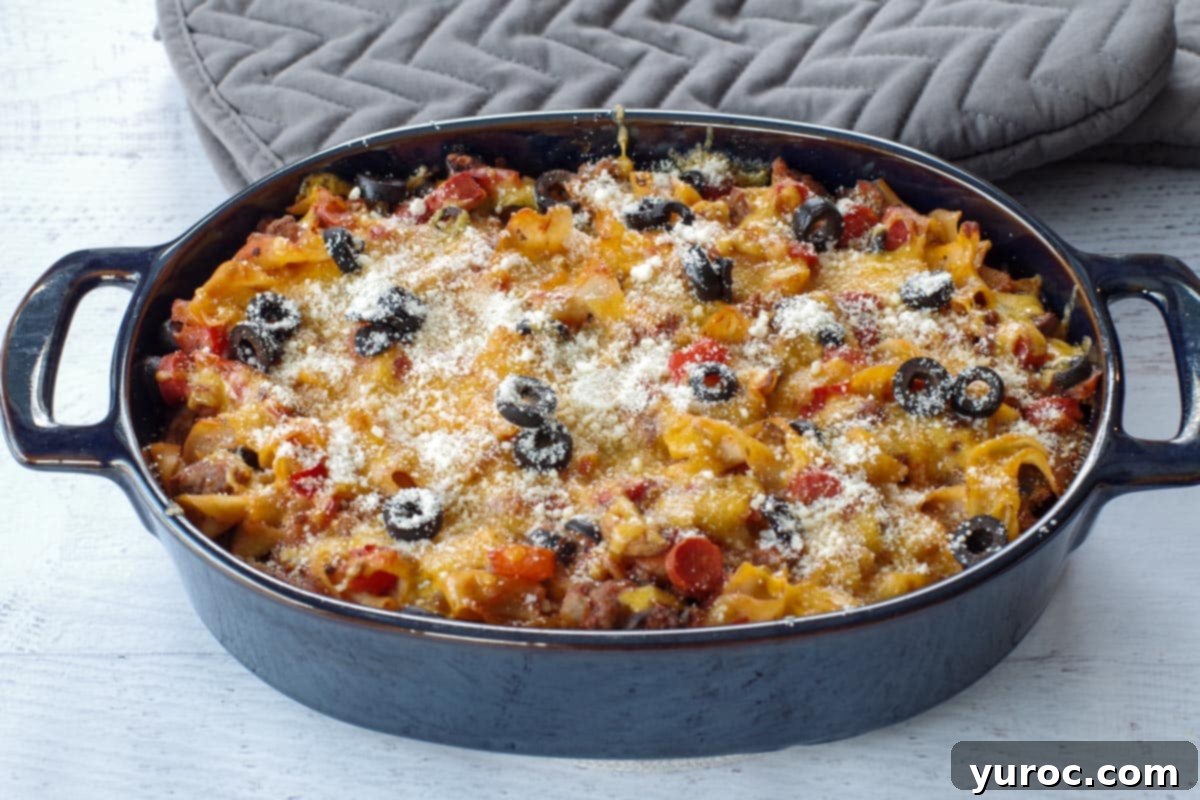 Guilt Free Pizza Casserole 1 healthy pizza casserole in a blue casserole dish with grey oven mitts in the background