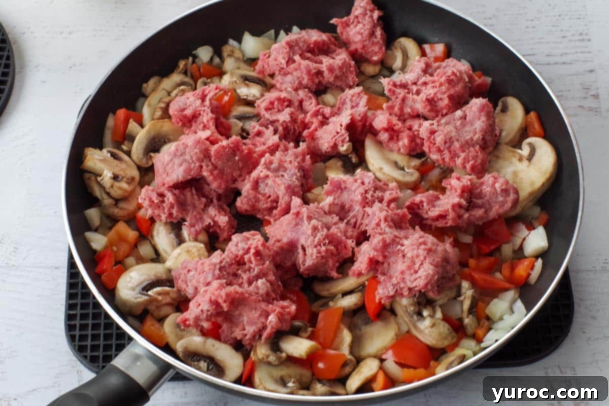 Guilt Free Pizza Casserole 4 ground beef added to vegetable mixture in skillet