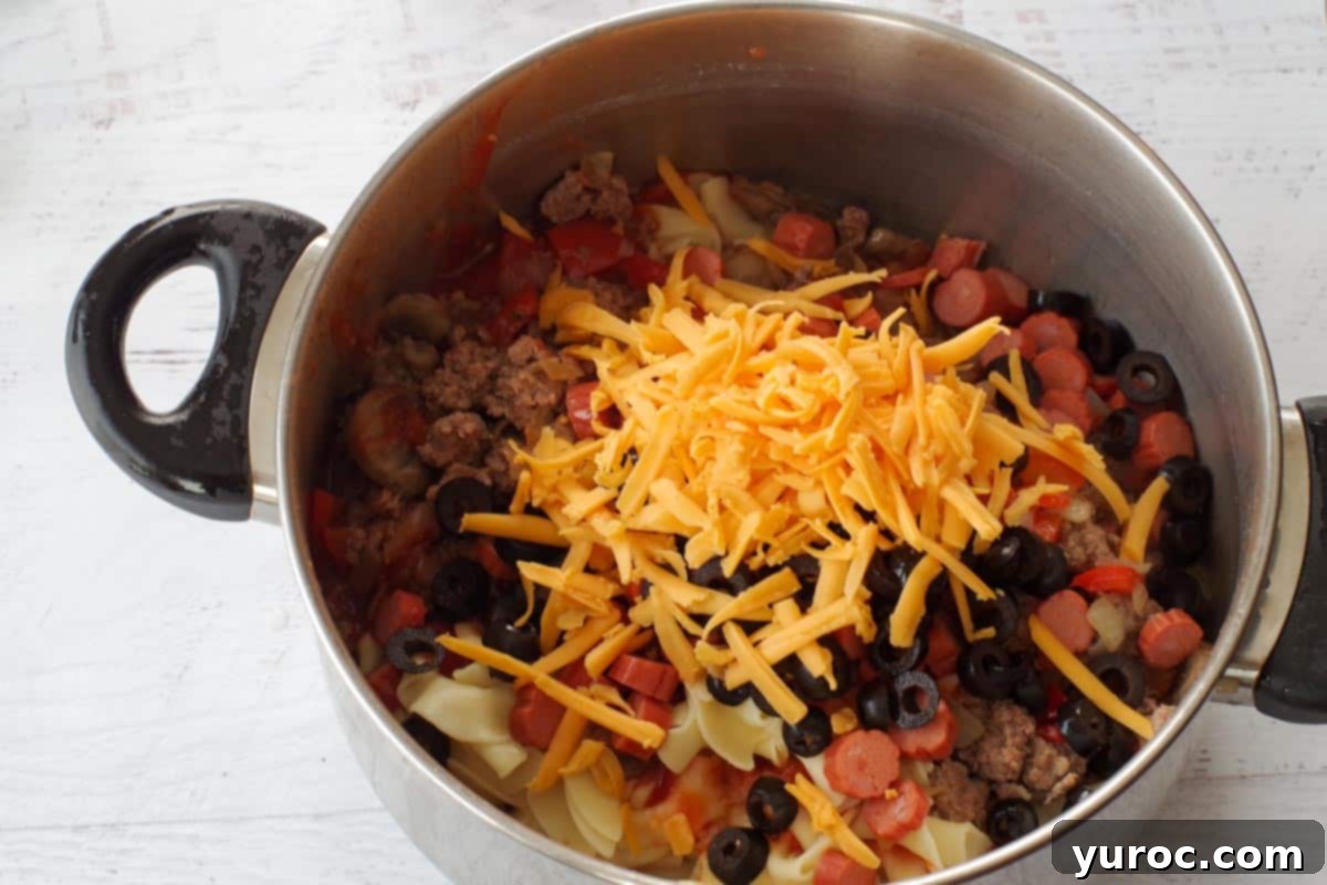 Guilt Free Pizza Casserole 6 ground beef mixture in pot with other ingredients (cheese etc0