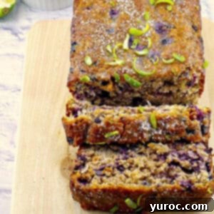 Cozy Blueberry Gingerbread Loaf 15 gingerbread loaf on a cutting board with blueberries and limes in background