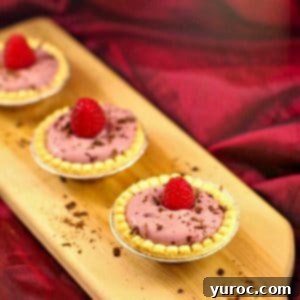 3 raspberry tiramisu tarts on a narrow wooden cutting board