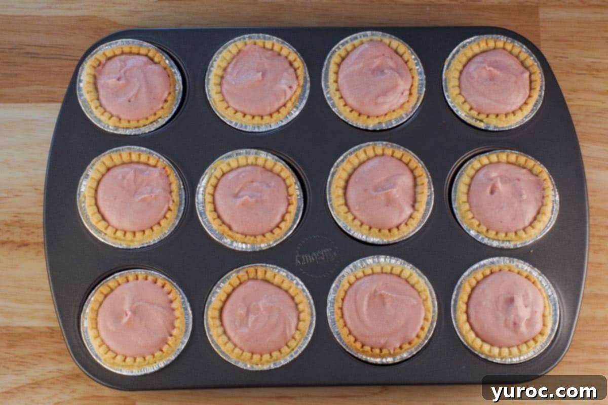Baked Tart Shells filled with raspberry tiramisu filling.