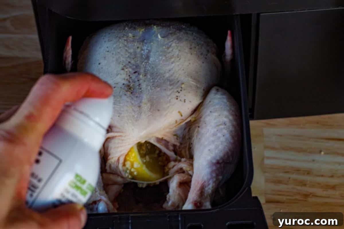 Whole roast chicken being sprayed with cooking oil.