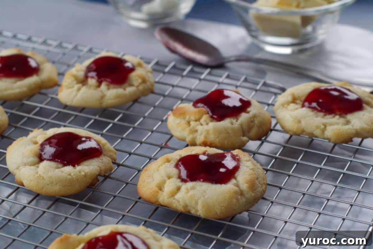 cookies with jam spooned on top, on a cooling rack