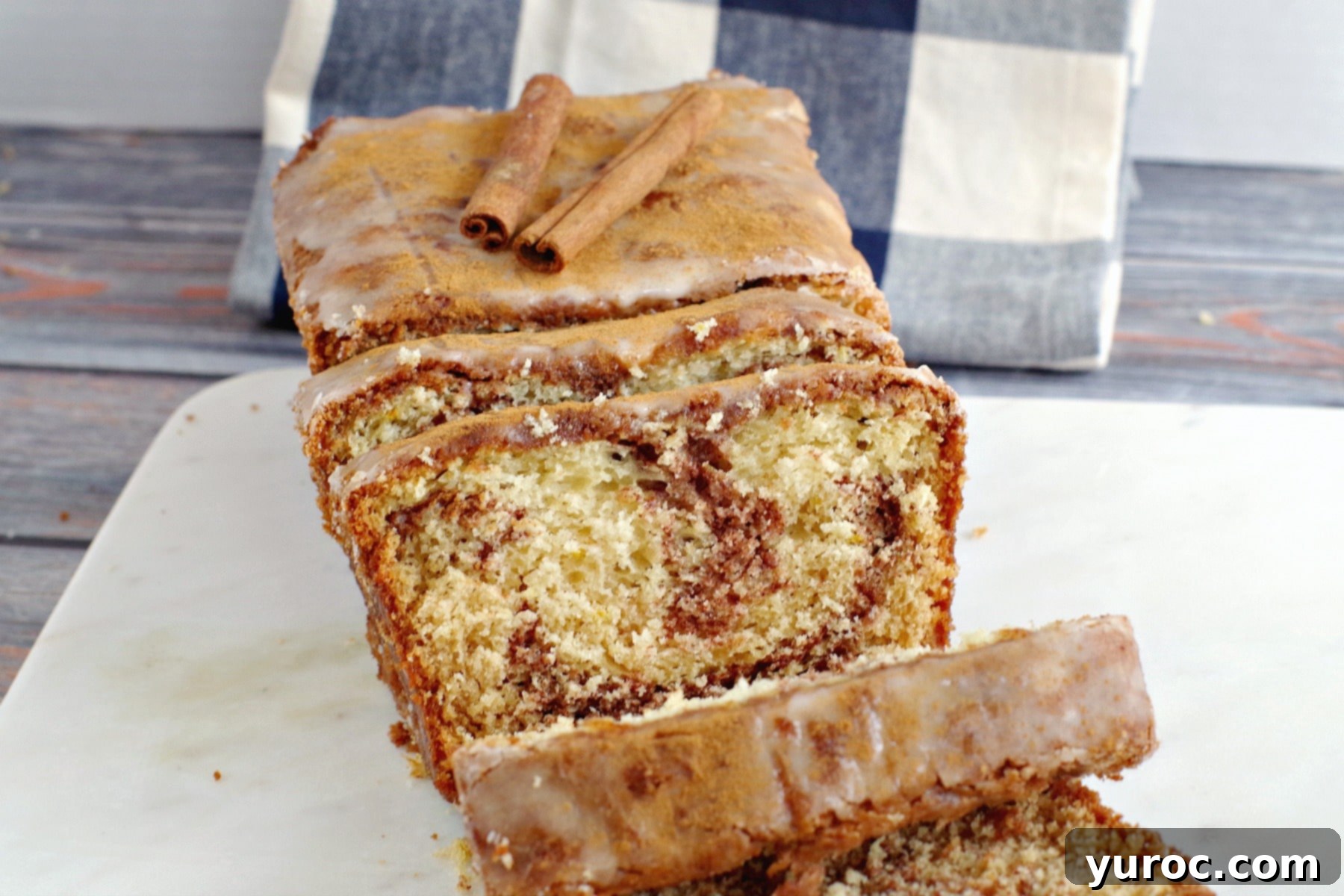 Deliciously sliced cinnamon swirl bread resting on a elegant marble board, ready to be enjoyed.