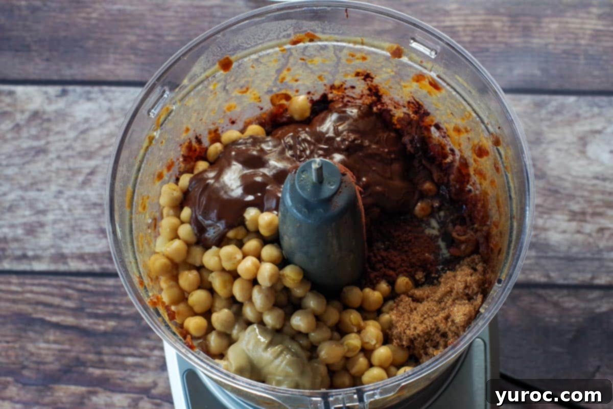 Decadent Dark Chocolate Date Hummus 6 All the remaining dark chocolate hummus ingredients, excluding the mini chocolate chips, are added to the food processor bowl with the processed dates, ready for blending.