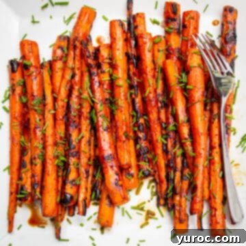 grilled balsamic glazed carrots on a white surface, with a fork