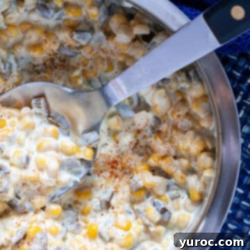 Jalapeno creamed corn in a metal bowl, with a metal serving spoon