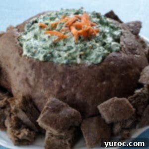 Ultimate Pumpernickel Spinach Dip 11 pumpernickel spinach dip bread bowl, surrounded by bread on a white plate