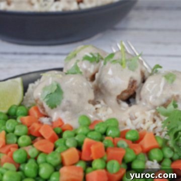 turkey pesto meatballs on rice with mixed vegetables, on a black plate