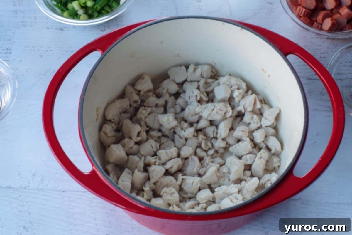 cooked, cubed chicken breast in an orange Dutch oven