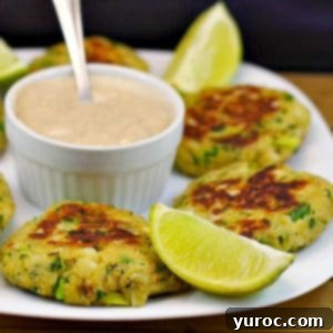 Golden Salmon Cakes with Zesty Ginger Lime Cream 14 Canned salmon patties on white plate, with dip in the middle and lime wedges