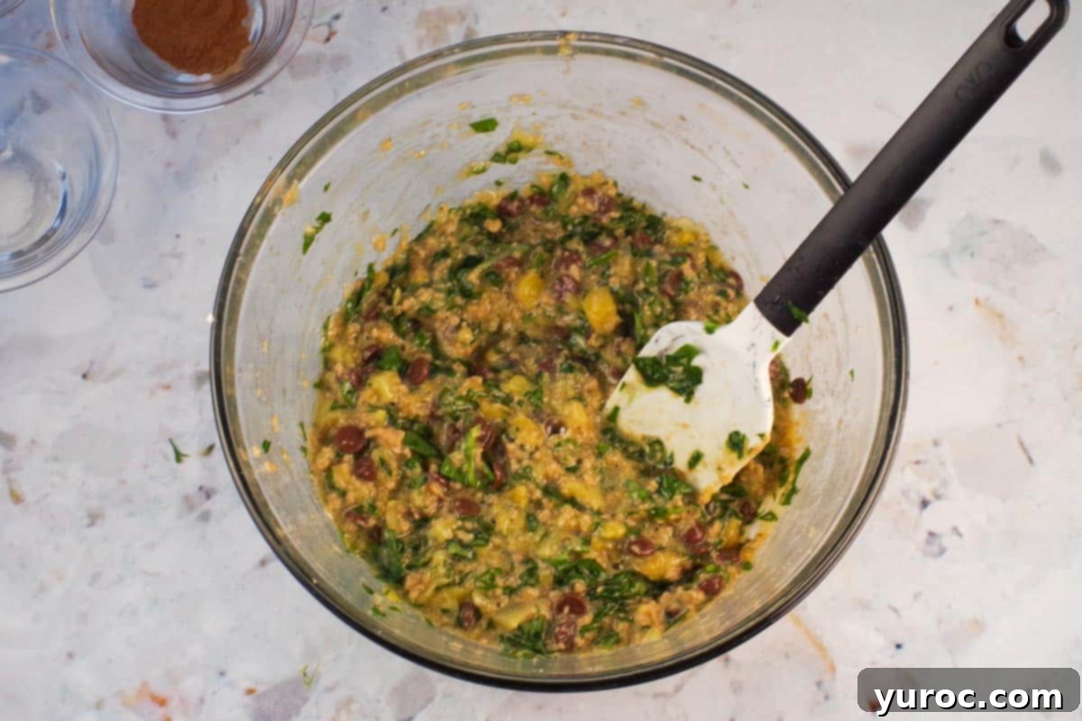 Wet ingredient mixed together in large glass bowl with spatula.