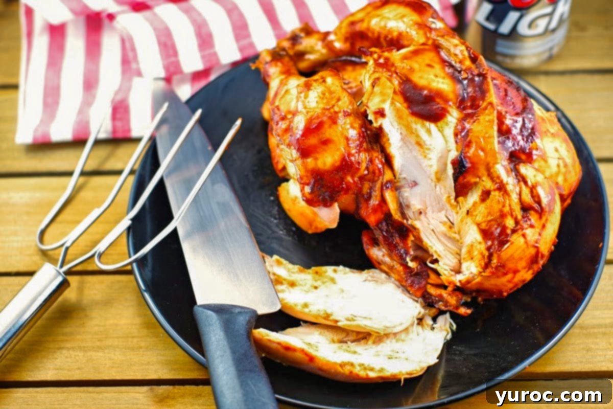 BBQ Beer Can Chicken 5 beer can chicken, sliced, on a black plate, with a knife