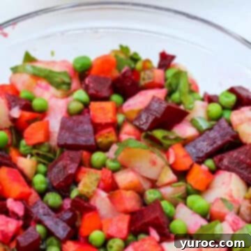 A colorful and fresh Ukrainian beet salad, or Vinegret, beautifully presented in a clear glass bowl, showcasing its vibrant ingredients.
