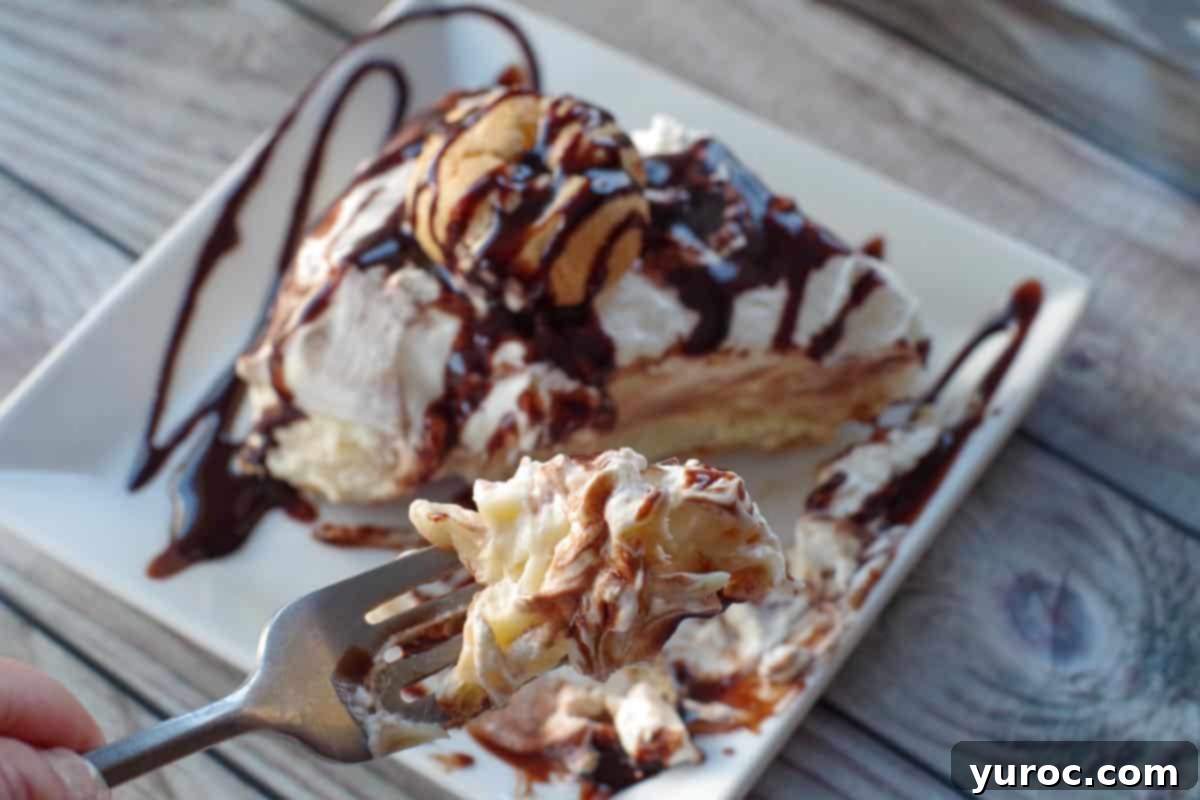 A bite of No-Bake Cream Puff Dessert held by a fork over a full slice of the dessert, highlighting the creamy layers and fluffy texture.