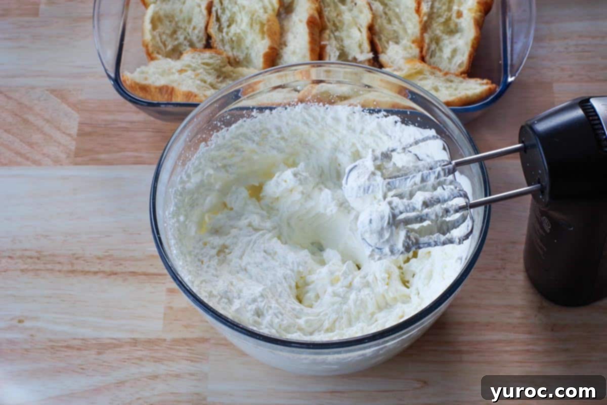 Thick, stiff peaks of whipped cream in a glass bowl, ready for layering.