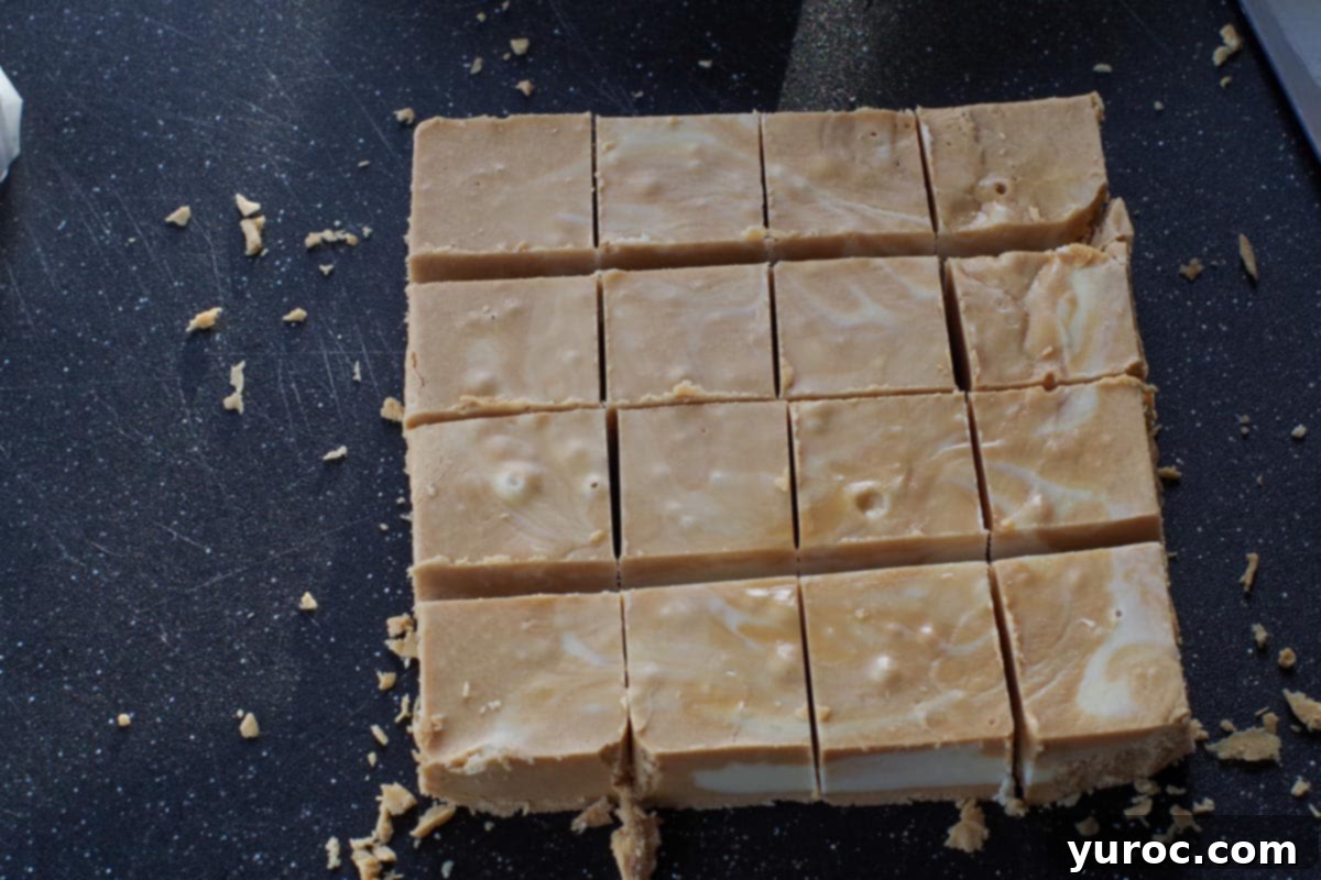 fudge cut into 1 inch squares on a black cutting board