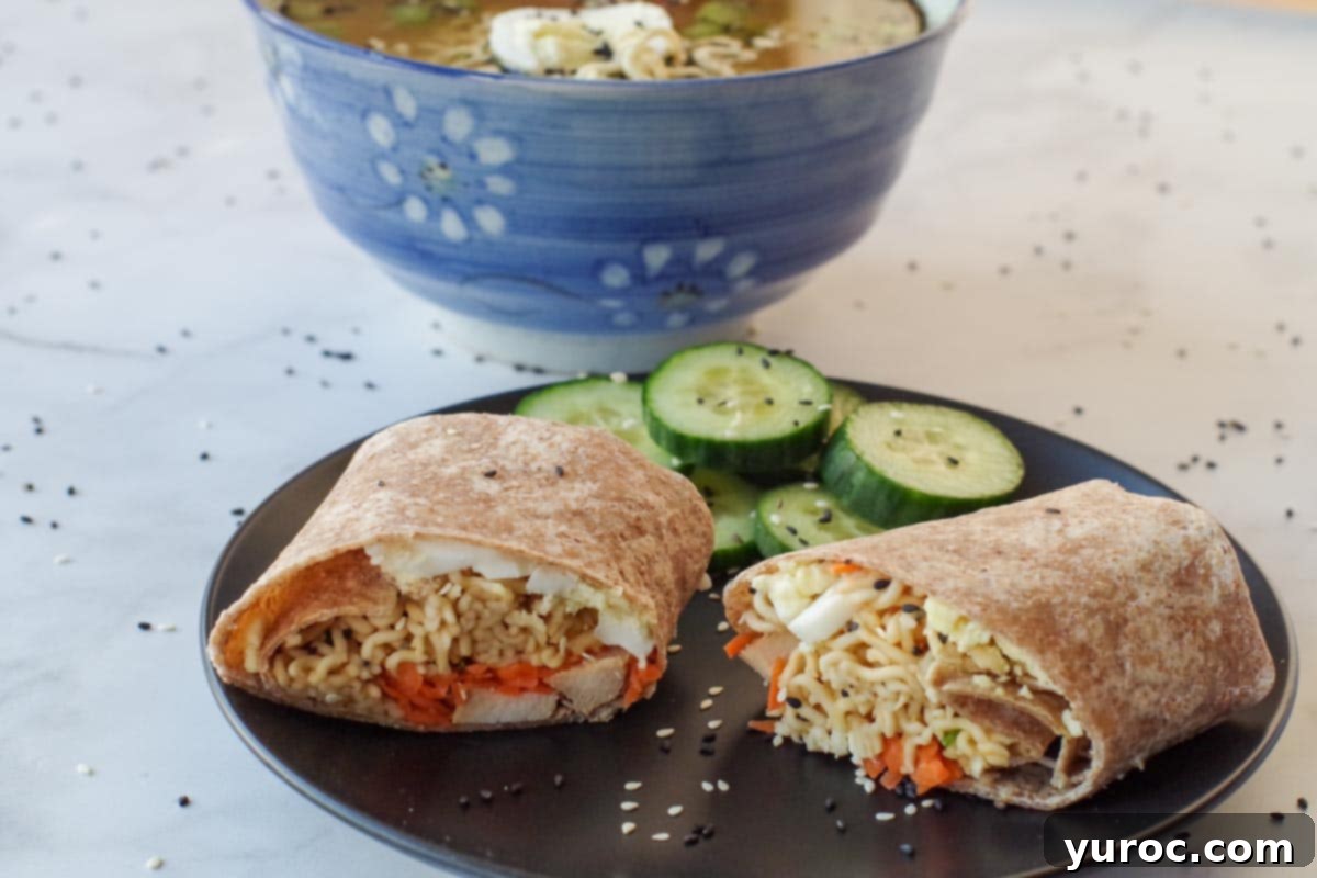Ramen wrap on a black plate, sliced in two pieces, with cucumbers on plate and bowl of ramen soup in the background