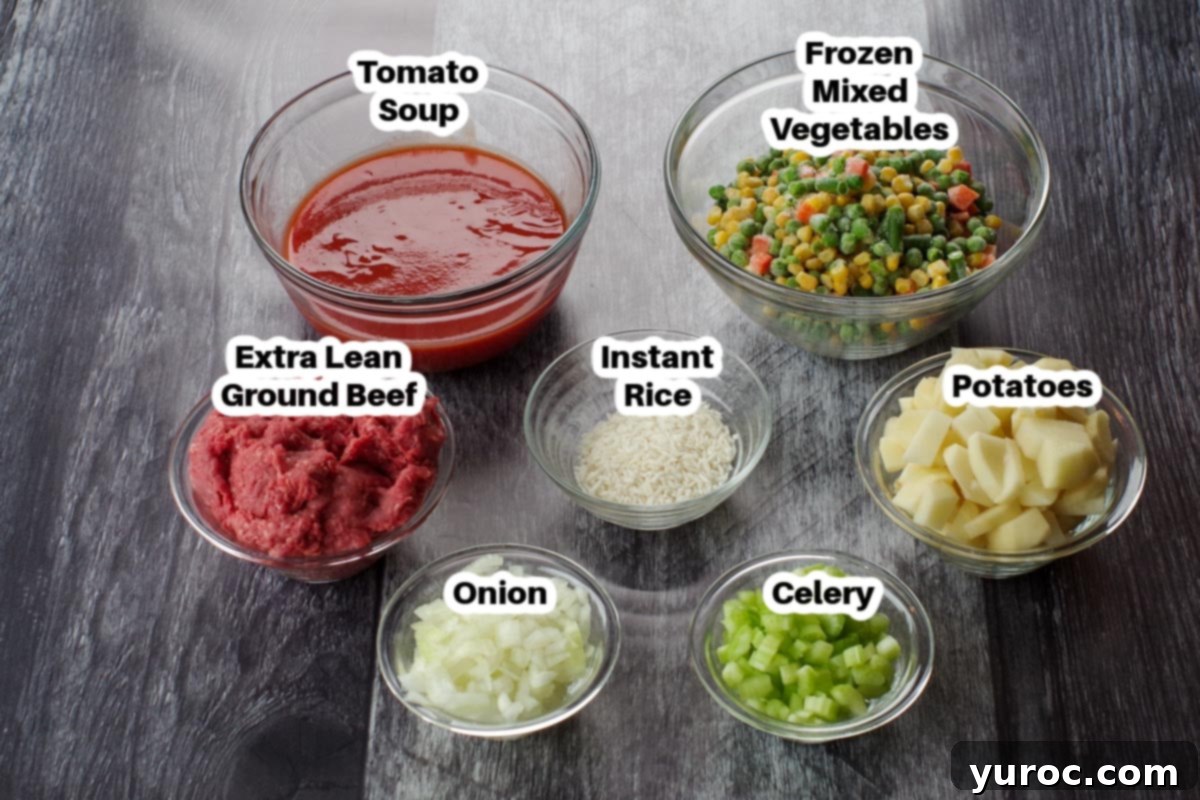 ingredients for shipwreck casserole on a faux grey wood surface in glass dishes, labelled