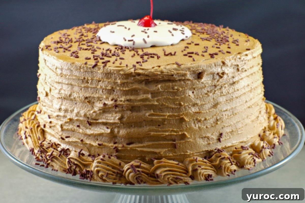 whole root beer float cake on a clear glass cake platter with black background