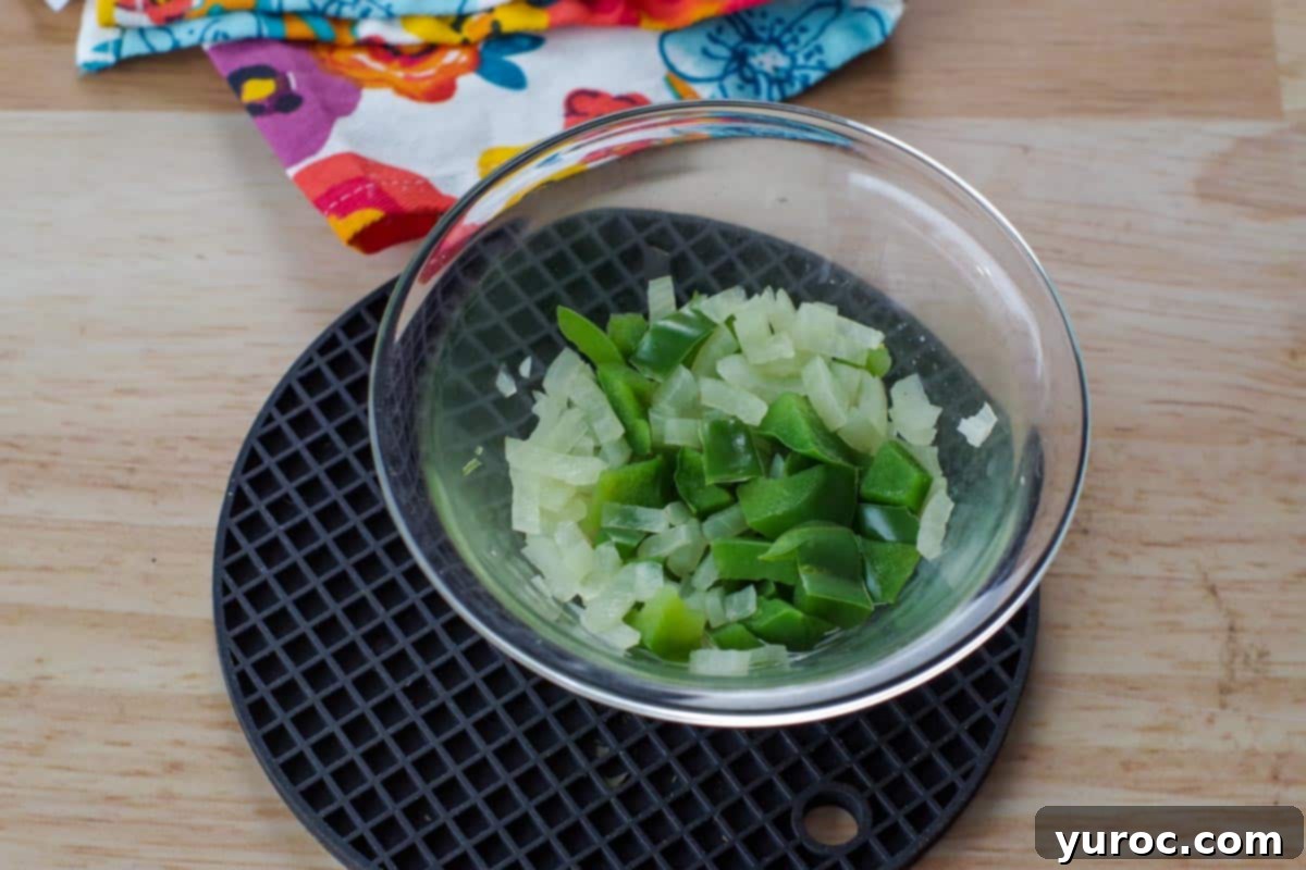 onions and green peppers cooked in a glass bowl on black trivet