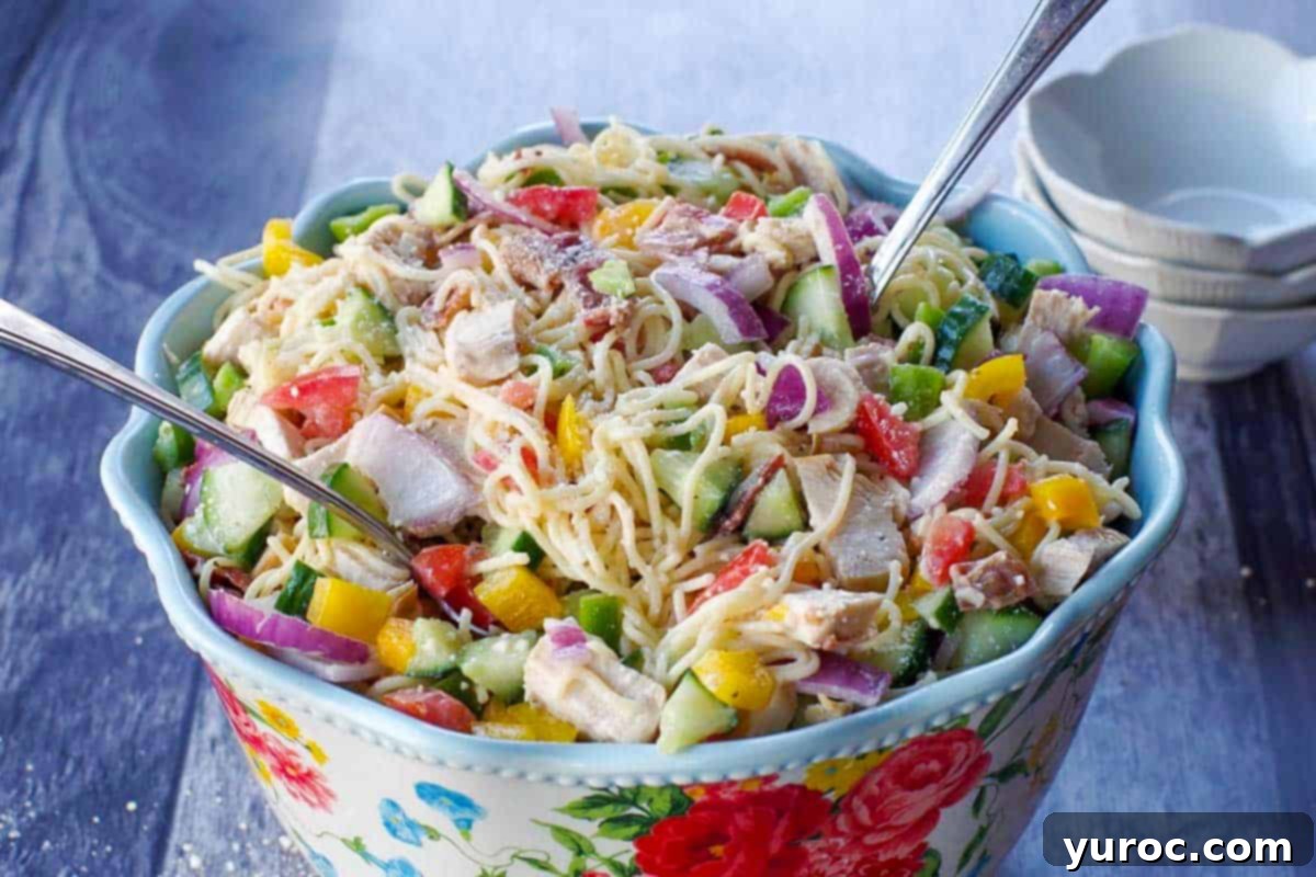 Ultimate Creamy Bacon Ranch Chicken Pasta Salad 5 chicken bacon ranch pasta salad in a flowered bowl with a spoon