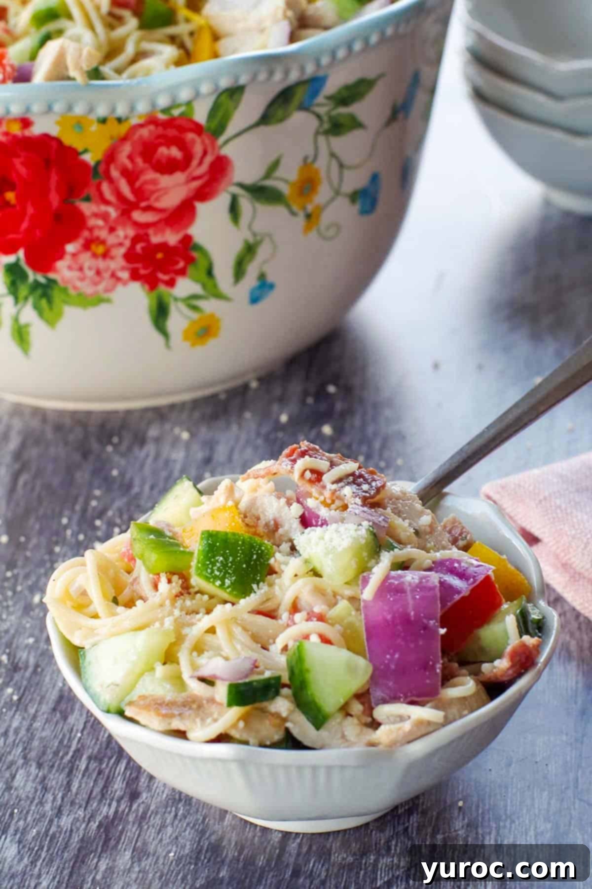 Ultimate Creamy Bacon Ranch Chicken Pasta Salad 6 chicken bacon ranch pasta salad in a small white bowl, with a fork and a large bowl of salad in background