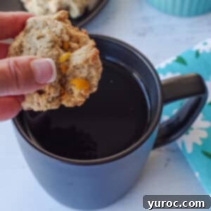 Sweet & Tart Rhubarb Oat Cookies 18 A delicious rhubarb oatmeal cookie being dipped into a black mug of coffee, highlighting its appealing texture and color.