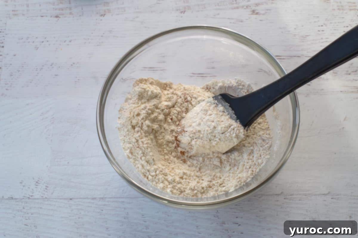 Sweet & Tart Rhubarb Oat Cookies 7 All-purpose flour, cinnamon, and baking soda are thoroughly mixed together in a separate medium glass bowl, forming the dry ingredients mixture.