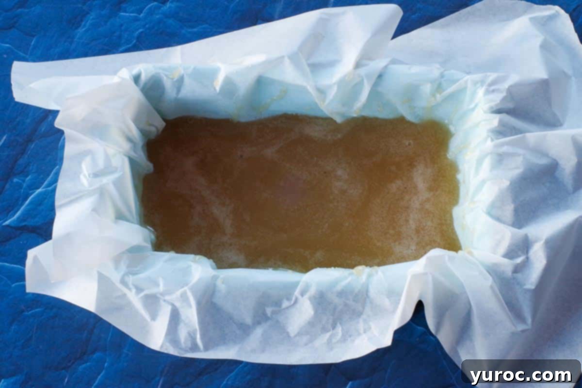 Decadent Salted Soft Butter Toffee 9 The perfectly cooked toffee mixture being carefully poured into a parchment-lined loaf pan for cooling and setting.