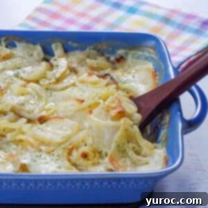 cooked scalloped potatoes without cheese in a blue casserole dish with a wooden spoon and a checkered tea towel in the background