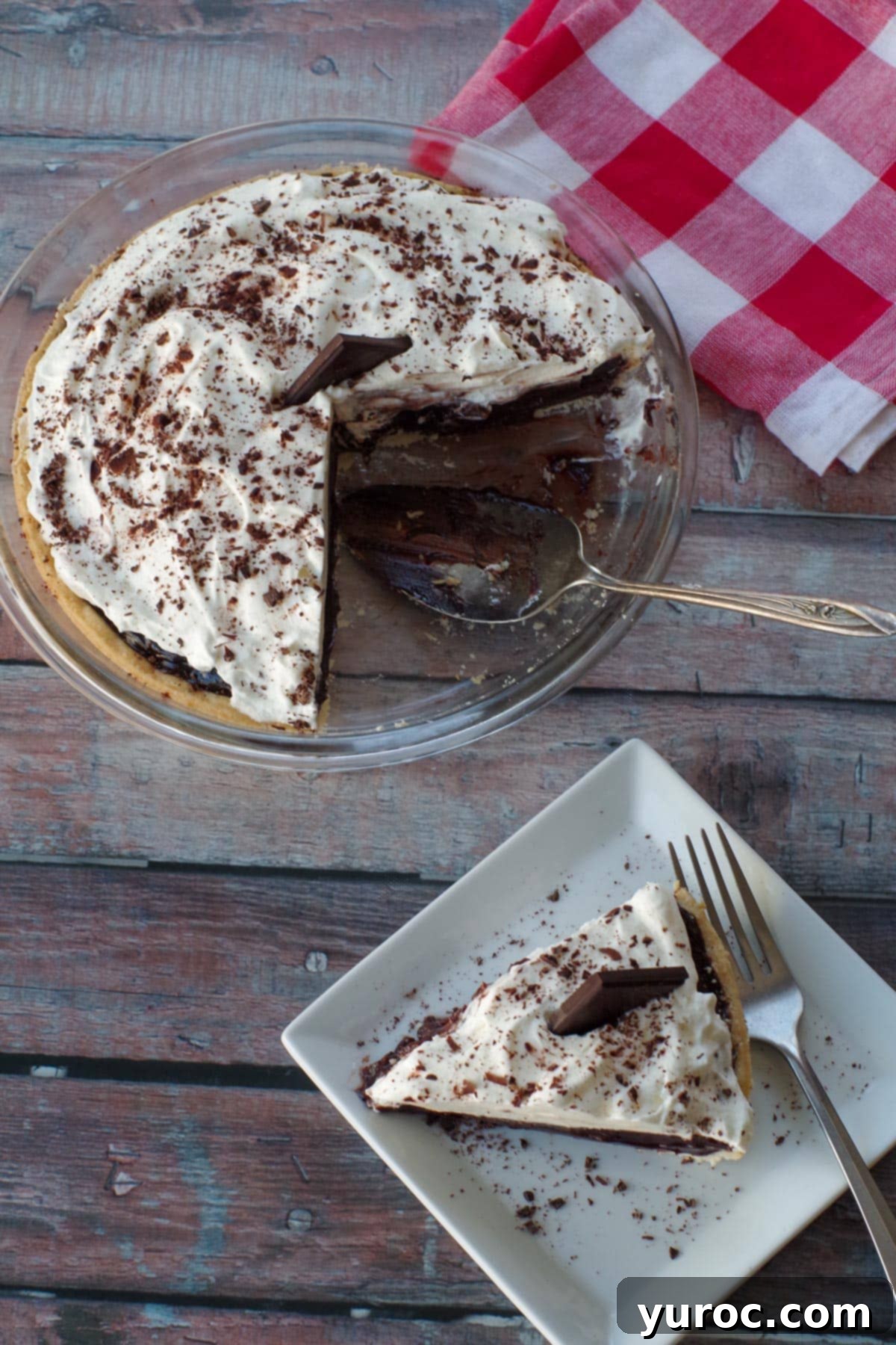 Timeless Chocolate Pie 2 Top view of a decadent old fashioned chocolate pie, with a piece served on a white plate and the remaining pie in a pie pan