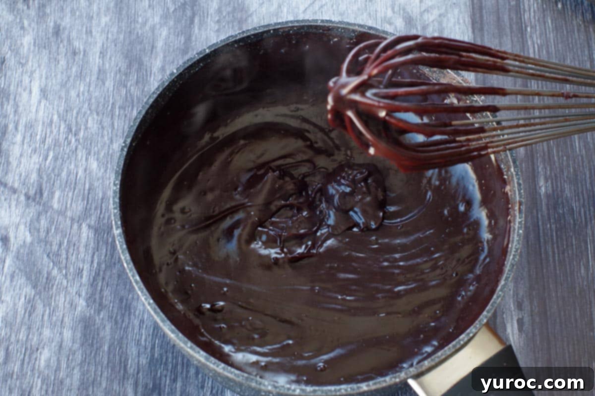Timeless Chocolate Pie 5 Thickened chocolate pudding filling in a pot with a whisk