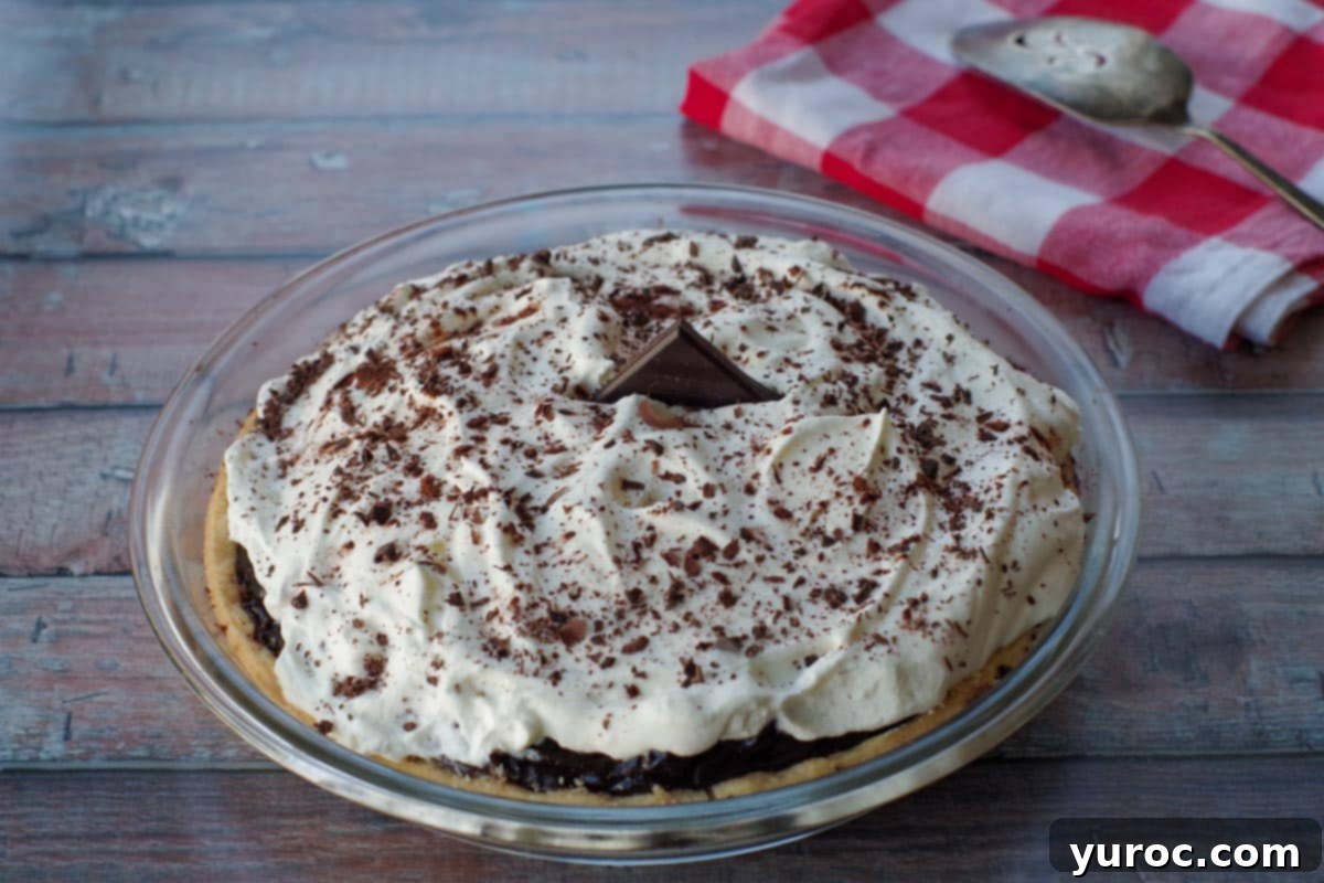 Timeless Chocolate Pie 9 Beautifully garnished chocolate pie in a glass pie dish, with a red and white checkered towel in the background