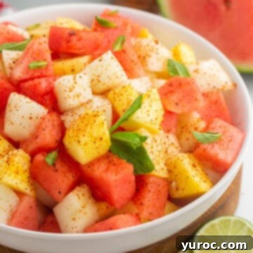 What to Serve with Carnitas: 25 Irresistible Recipes 15 Mexican Fruit Salad in a white bowl, showing colorful tropical fruits.