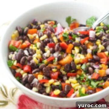 What to Serve with Carnitas: 25 Irresistible Recipes 8 Mexican bean salad in a white bowl, with a spoon for serving.