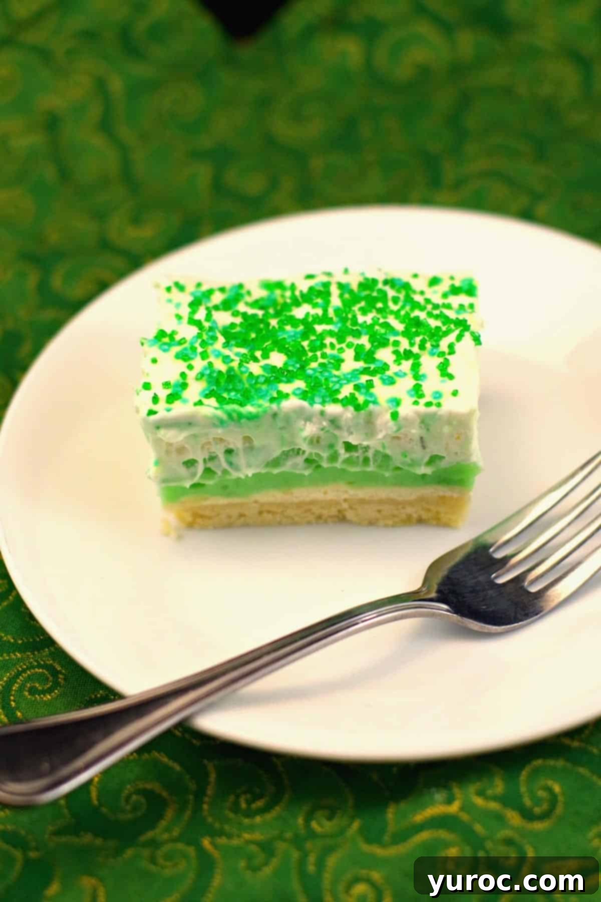 Pistachio green dessert on a white plate with a fork. 