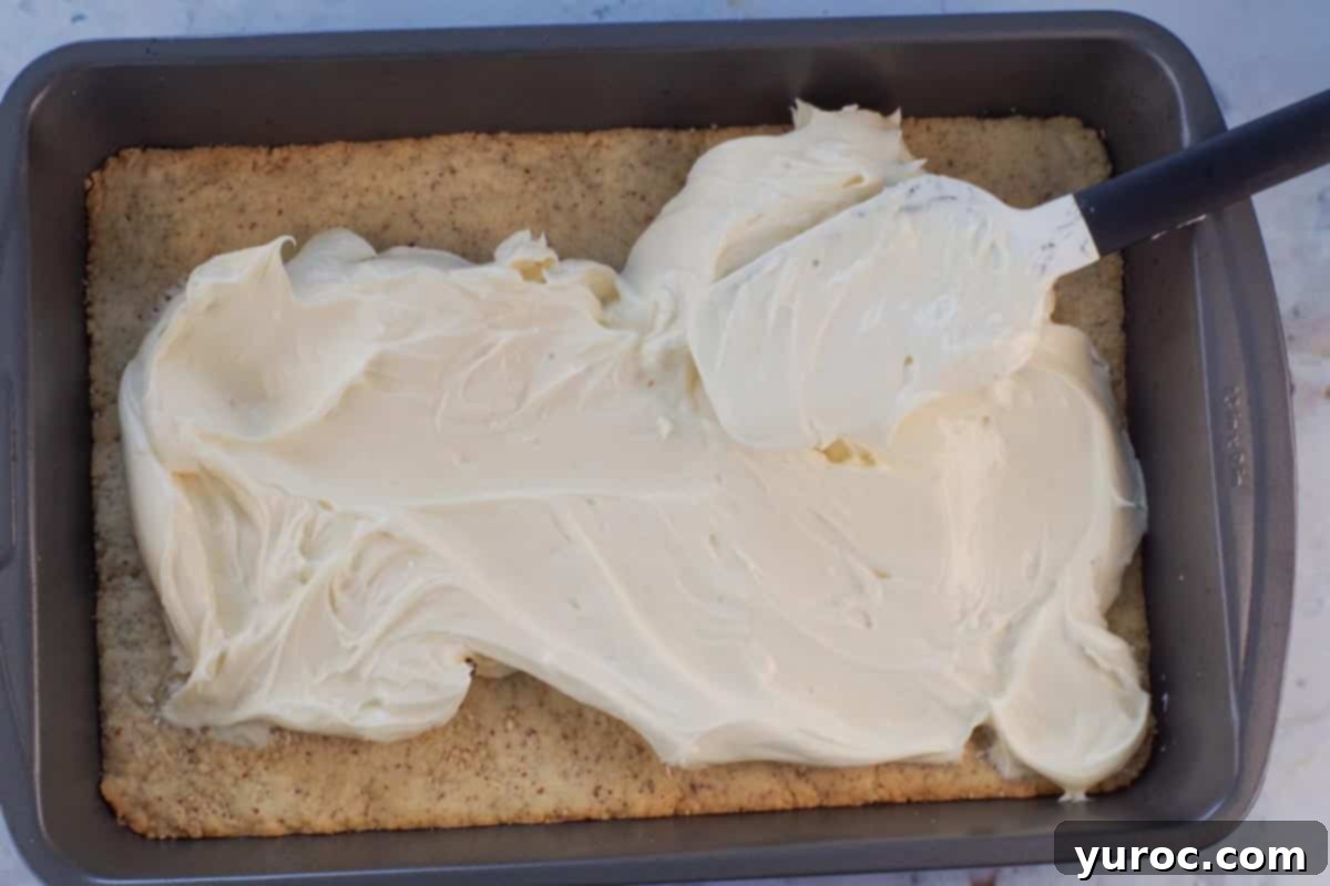 Pistachio dessert cream cheese layer being spread over base.