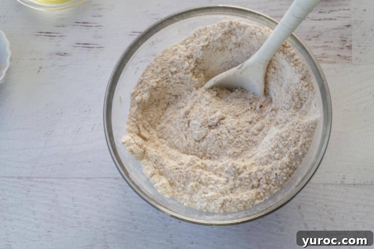 dry ingredients mixed together in glass bowl, with a spoon