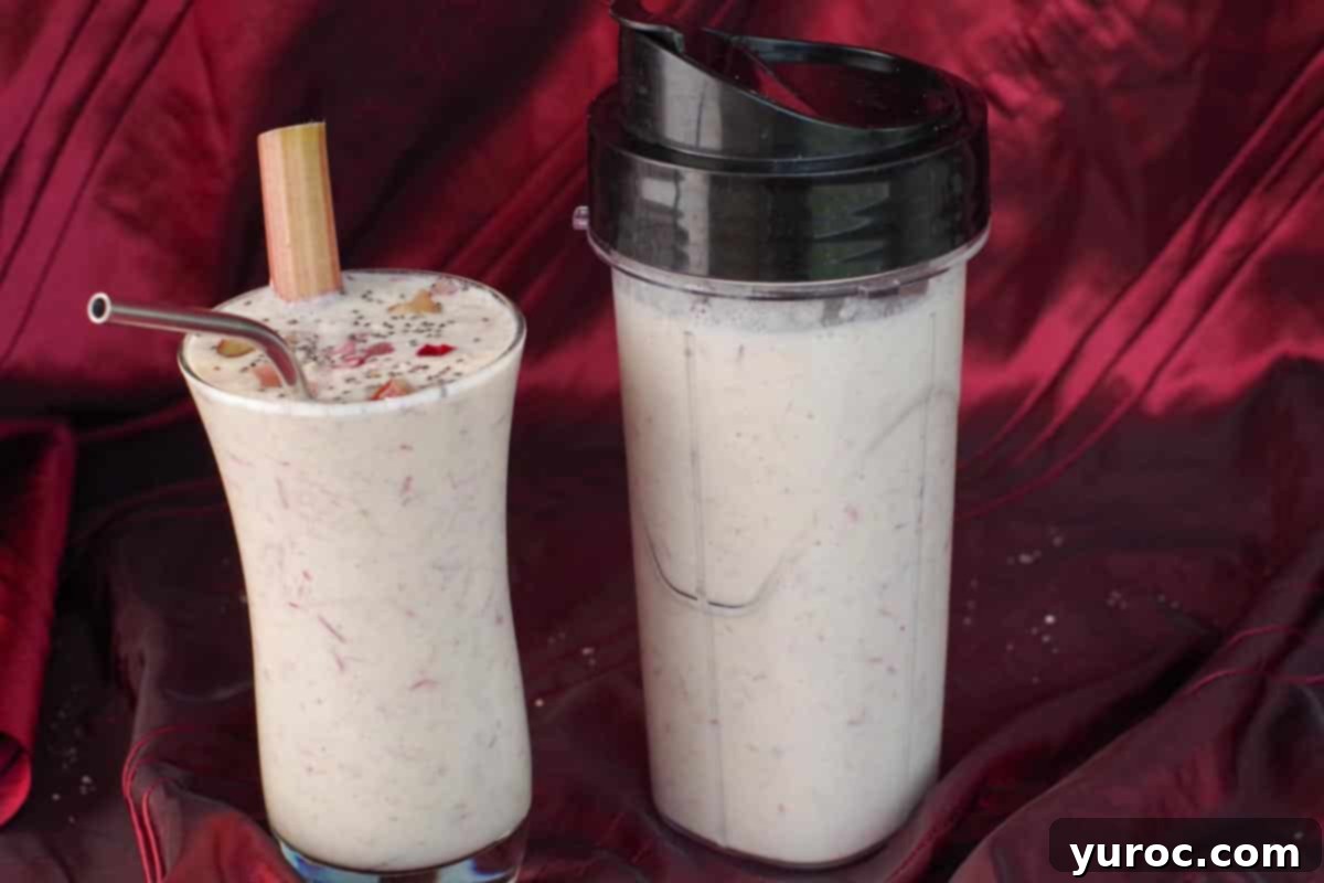 A fresh rhubarb smoothie displayed next to a sealed storage container holding another portion of the smoothie