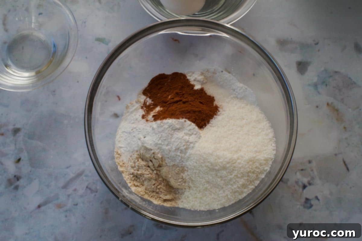 Dry ingredients for pancakes in a clear glass bowl, showcasing their texture.